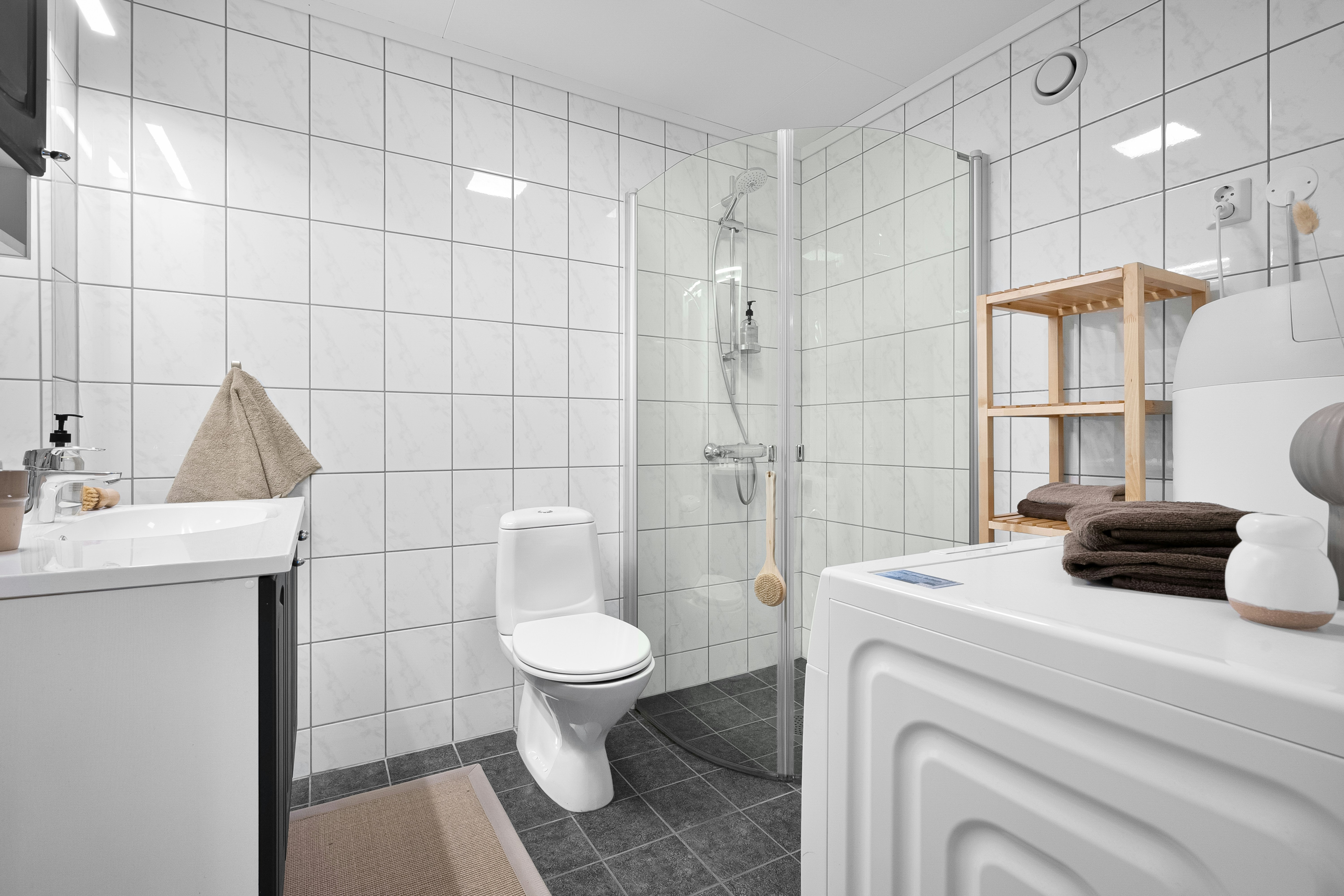 Modern banyo içinde klozet, lavabo ve duş alanı görünümü